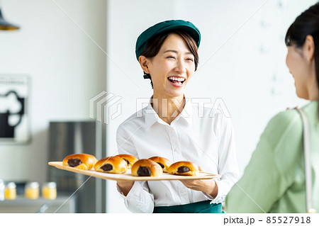 お客様に焼きたてパンを薦めるミドル女性の店員 85527918