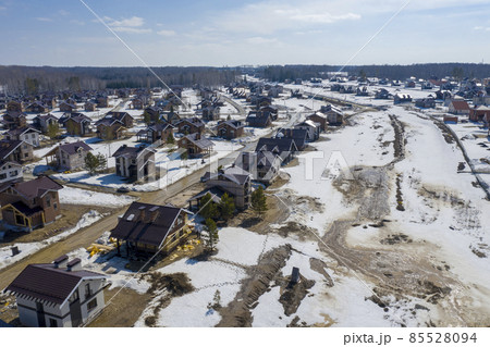 Aerial view of a cottage settlement under construction in the forest in Siberia in spring Aerial view of a cottage settlement under construction in the forest in Siberia in spring 85528094