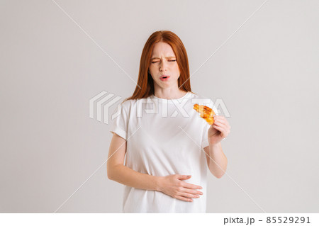 Studio portrait of attractive sick young woman closed eyes feeling pain in stomach after eating pizza, suffering abdomen ache. Studio portrait of attractive sick young woman closed eyes feeling pain in stomach after eating pizza, suffering abdomen ache. 85529291