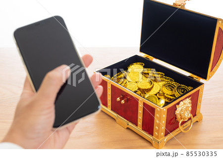 スマートフォン、スマホ使う男性と沢山の金貨が入った宝箱 資産運用 一攫千金 副業 臨時収入 大当たり スマートフォン、スマホ使う男性と沢山の金貨が入った宝箱 資産運用 一攫千金 副業 臨時収入 大当たり 85530335