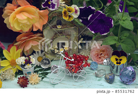 Lovely summer still life with tiny bicycle, doll house, flowers and berries in the garden.  Greeting card, wedding or birthday concept. Vintage romantic background 85531762