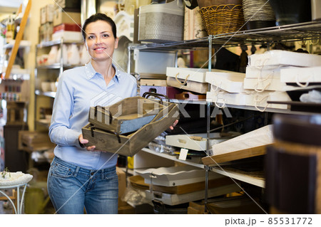 Positive female holding boxes in home decor store Positive female holding boxes in home decor store 85531772