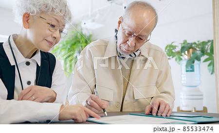 書類に記入するシニアカップル 85533474