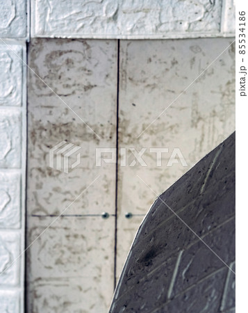 The wallpaper begins to peel off. Old white bricks wallpaper peeled off from the wall inside the room due to moisture or poor quality gluing. Repair and construction services concept. Selective Focus. 85534186