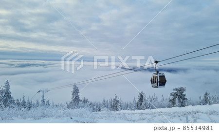 Empty white red closed ski lift cabin no people and white dramatic snowy mountains background. End of season concept. Ski resorts closure Empty white red closed ski lift cabin no people and white dramatic snowy mountains background. End of season concept. Ski resorts closure 85534981