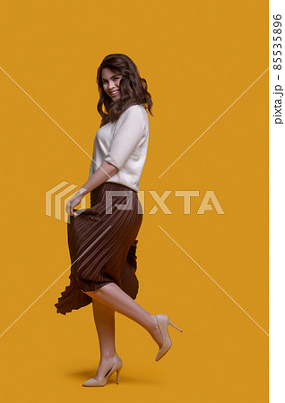 Trendy lady in a long pleated skirt enjoying her dance 85535896