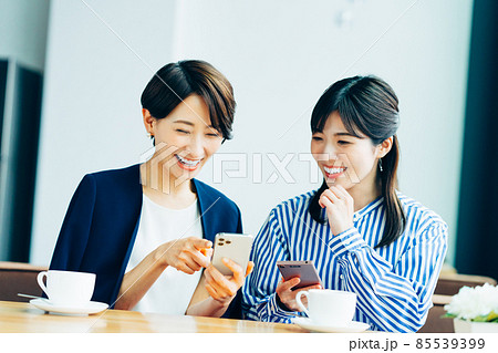 カフェで友達とスマホを見るミドル女性 85539399