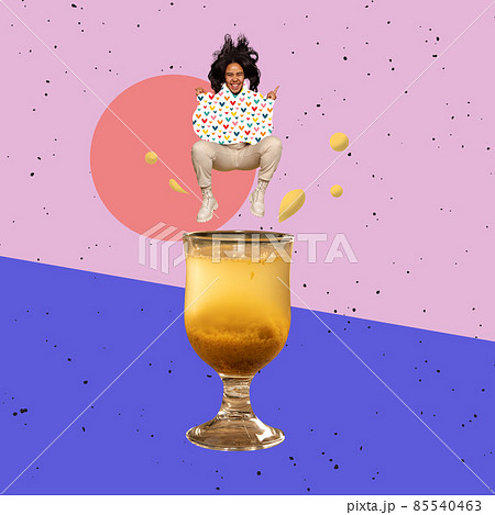 Contemporary art collage, modern design. Party mood. Young happy girl jumping into cocktail glass with hot drink Contemporary art collage, modern design. Party mood. Young happy girl jumping into cocktail glass with hot drink 85540463