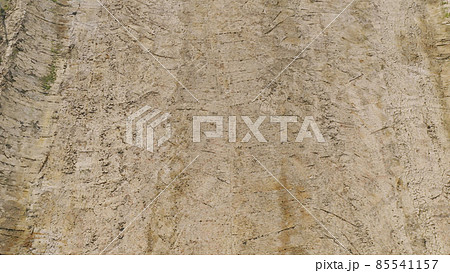 Aerial top view of dry ground rough cracks in the land with sand in paddy rice field. serious water shortages and Drought barren arid pattern texture background. Aerial top view of dry ground rough cracks in the land with sand in paddy rice field. serious water shortages and Drought barren arid pattern texture background. 85541157