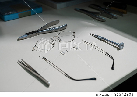Disassembled glasses frame and tools. Optics work table. 85542303