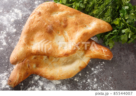 Freshly baked Georgian wheat flat bread Shotis puri close-up on the table. horizontal top view 85544007