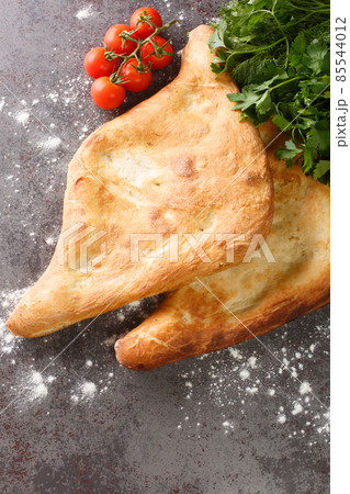 Shotis puri or simply shoti is a type of traditional Georgian bread made of white flour and shaped like a canoe close up. Vertical top view 85544012