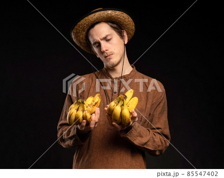 Young man with banana on black Young man with banana on black 85547402