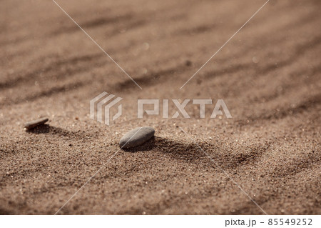 Couple of stones naturally located on windy sandy beach close up. Summer background 85549252