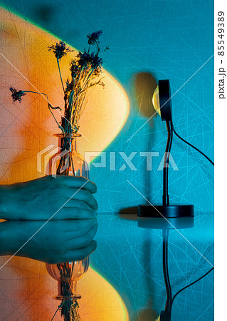 Sunset LED RGB lighting decor. Shadow on surface illuminated by spotlight beam. Vertical photo 85549389