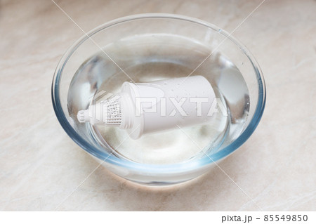 Filling a new filter with water prior to installation. Home filter for water purification in a jug. 85549850