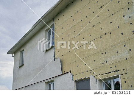 Insulation of a residential building. Exterior repair work on the building, insulation and cladding of the facade of the house. High quality photo 85552111