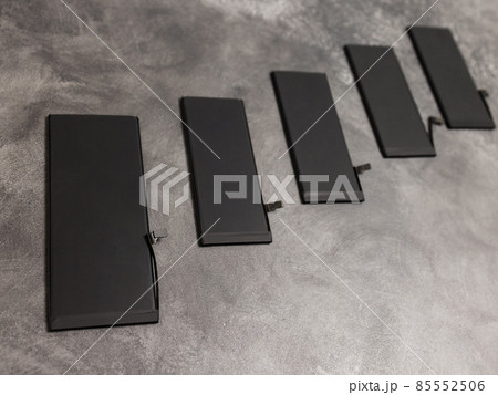 battery phone lies on a gray background. battery phone lies on a gray background. 85552506