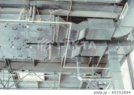 Ventilation pipes in silver insulation material. Chromed pipes hanging from ceiling inside premises. Concept is a restaurant exhaust system. Several hoods in room, bottom view. Ventilation system Ventilation pipes in silver insulation material. Chromed pipes hanging from ceiling inside premises. Concept is a restaurant exhaust system. Several hoods in room, bottom view. Ventilation system 85552694