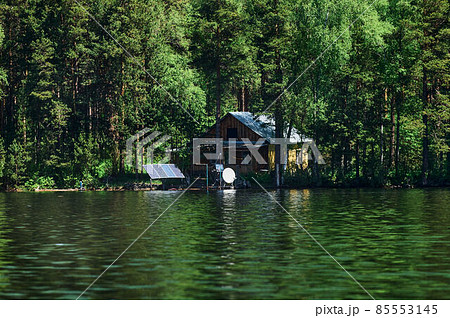Breathtaking and colourful scenery of a fairy tale view with a rocky house next to the lake and a small boat in front of it in a beautiful natural environment. Stunning nature wallpaper background. 85553145
