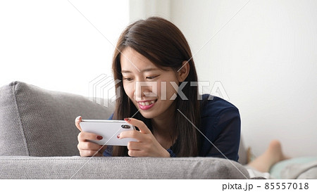 ソファでスマートフォンを使う女性 ソファでスマートフォンを使う女性 85557018