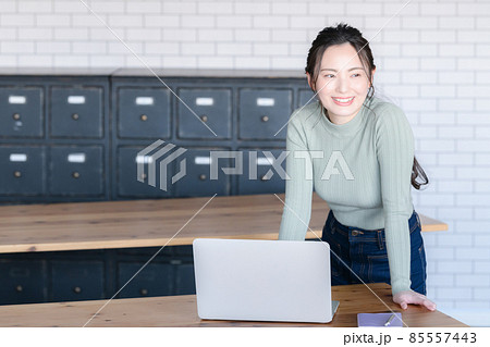 パソコンのそばで微笑む美しい日本人女性　コピースペースあり 85557443