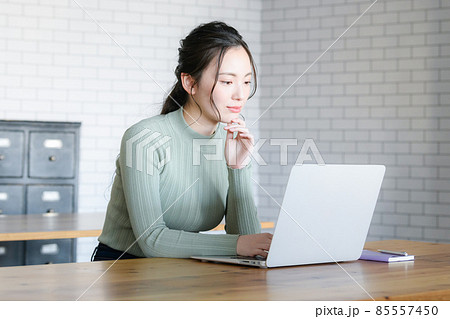 パソコンを見ながら真剣なまなざしで考える日本人女性　コピースペースあり 85557450