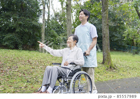 介護士と車椅子に乗る高齢者 屋外 介護士と車椅子に乗る高齢者 屋外 85557989