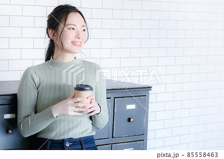 コーヒーを持って笑顔で休憩する女性　コピースペースあり 85558463
