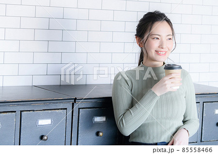 コーヒーを持って休憩する笑顔の女性　コピースペースあり 85558466