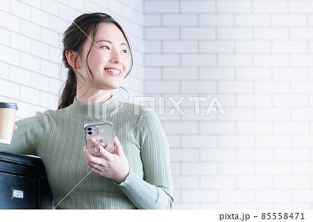 コーヒーを持って休憩する笑顔の女性 アップ コピースペースあり コーヒーを持って休憩する笑顔の女性 アップ コピースペースあり 85558471
