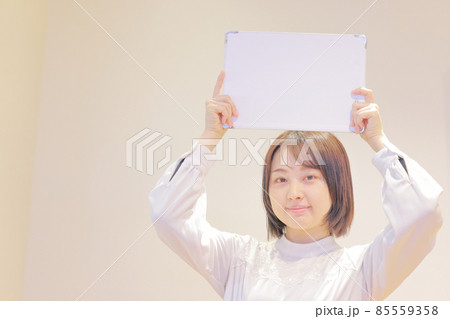 メッセージボードを頭の上に掲げる若い女性2 メッセージボードを頭の上に掲げる若い女性2 85559358