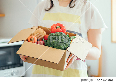 キッチンでダンボールに入った野菜を持つ女性（顔なし） 85562308