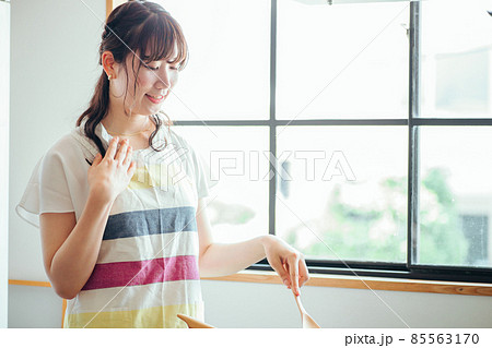 キッチンでフライパンを使う女性(疲れる) キッチンでフライパンを使う女性(疲れる) 85563170