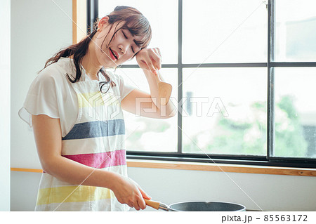 キッチンでフライパンを使う女性(疲れる) キッチンでフライパンを使う女性(疲れる) 85563172