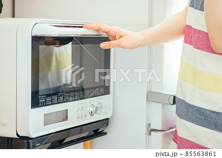 電子レンジを使う女性（顔なし） 85563861