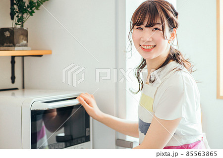 電子レンジを使う女性(笑顔) 電子レンジを使う女性(笑顔) 85563865