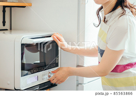 電子レンジを使う女性（顔なし） 85563866