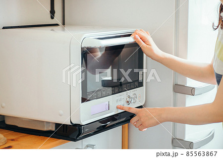 電子レンジを使う女性（顔なし） 85563867