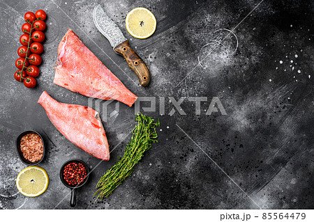 Whole raw red snapper fish, on black dark stone table background, top view flat lay, with copy space for text Whole raw red snapper fish, on black dark stone table background, top view flat lay, with copy space for text 85564479