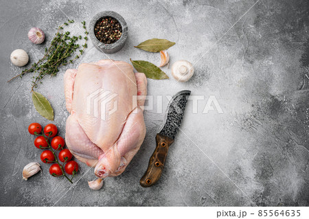 Whole raw chicken, on gray stone table background, top view flat lay, with copy space for text 85564635