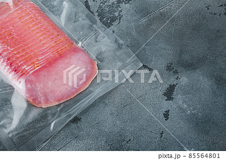 Cured meat pork ham, vacuum packed, on gray stone background, with copy space for text Cured meat pork ham, vacuum packed, on gray stone background, with copy space for text 85564801