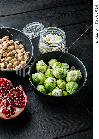 Gnarly garlic brussels ingredients, on black wooden table 85565014