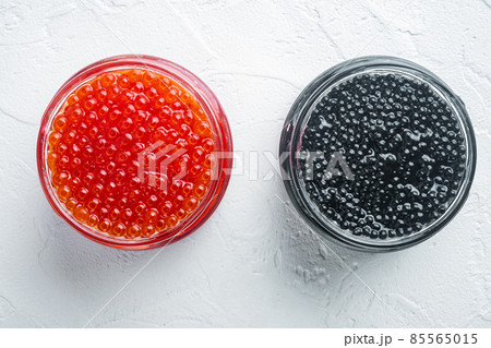Glass jars with black and red caviar, on white background, top view flat lay 85565015