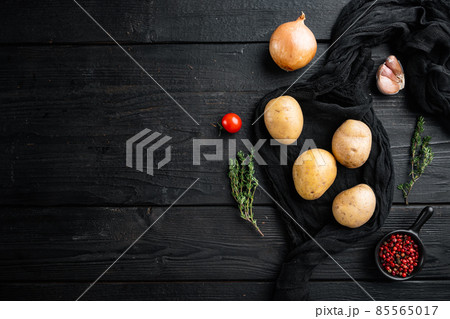 Fresh Pile of potatoes, on black wooden table background, top view flat lay , with space for text copyspace 85565017