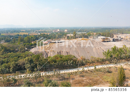 Aerial view of machine excavator trucks dig coal mining or ore with black grunge stone on ground in quarry with mountain hills. Nature landscape background in factory industry. Environment resources 85565356