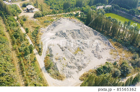 Aerial view of machine excavator trucks dig coal mining or ore with black grunge stone on ground in quarry with mountain hills. Nature landscape background in factory industry. Environment resources 85565362