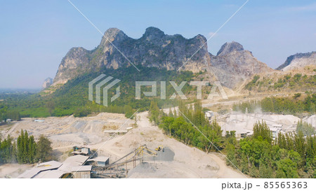 Aerial view of machine excavator trucks dig coal mining or ore with black grunge stone on ground in quarry with mountain hills. Nature landscape background in factory industry. Environment resources 85565363