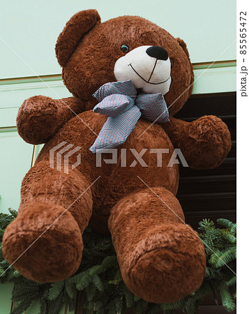 Soft brown bear toys on shop window Christmas fair store decorated with gifts garland lights illuminated New year retail Soft brown bear toys on shop window Christmas fair store decorated with gifts garland lights illuminated New year retail 85565472