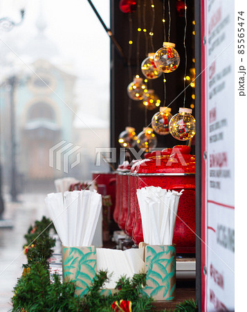 Red pots with mulled wine on Christmas market illuminated stall. Seasonal holiday street food beverages concept New year 85565474